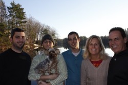 family posing together in front of a lake